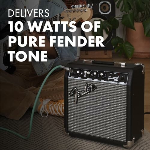 Fender amplifier with person playing guitar in background.